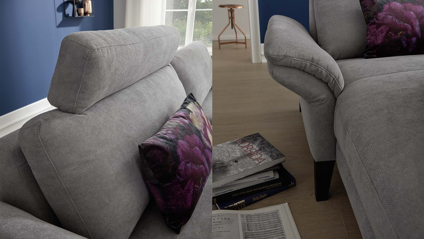 Blaues Wohnzimmer mit grauem Funktionssofa mit Relaxfunktion, Sitzverstellung und Kopflehnenverstellung.