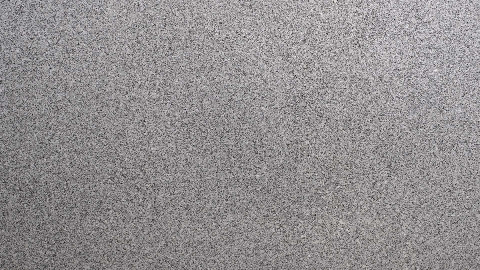 Naturstein Küchenarbeitsplatte mit weißer Grundfarbe im matten leather look mit grundsätzlich feiner Struktur und schwarz-grauen Sprenklern in der Farbe Gamma White.