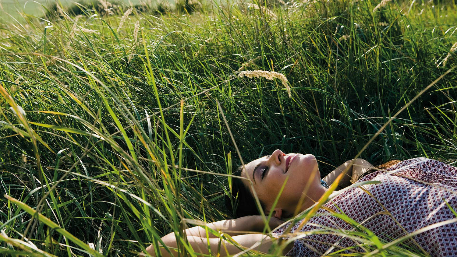 Dormiente Frau liegt im grünen Gras.
