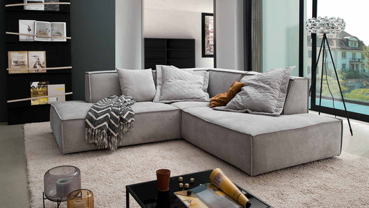 Modulares Sofa in grau mit dicker Naht.