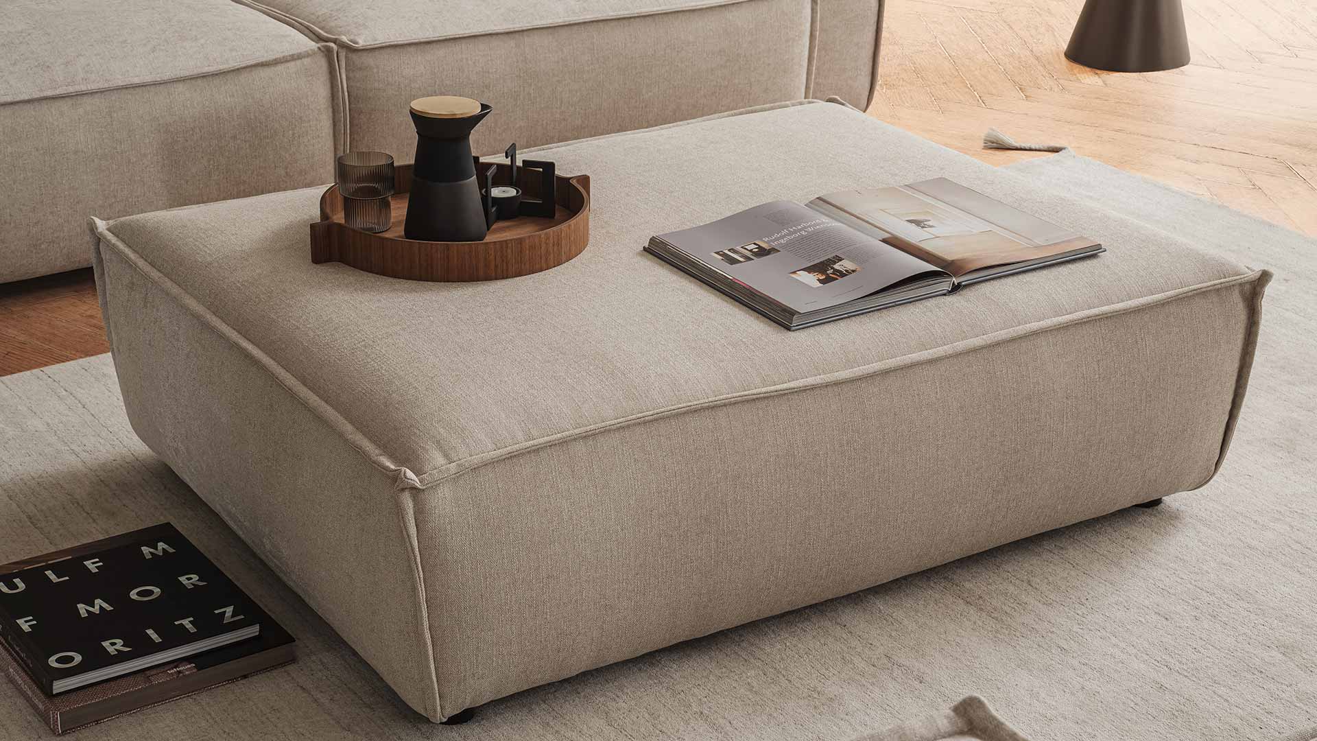 Modulares Sofa mit Hocker als Tisch.