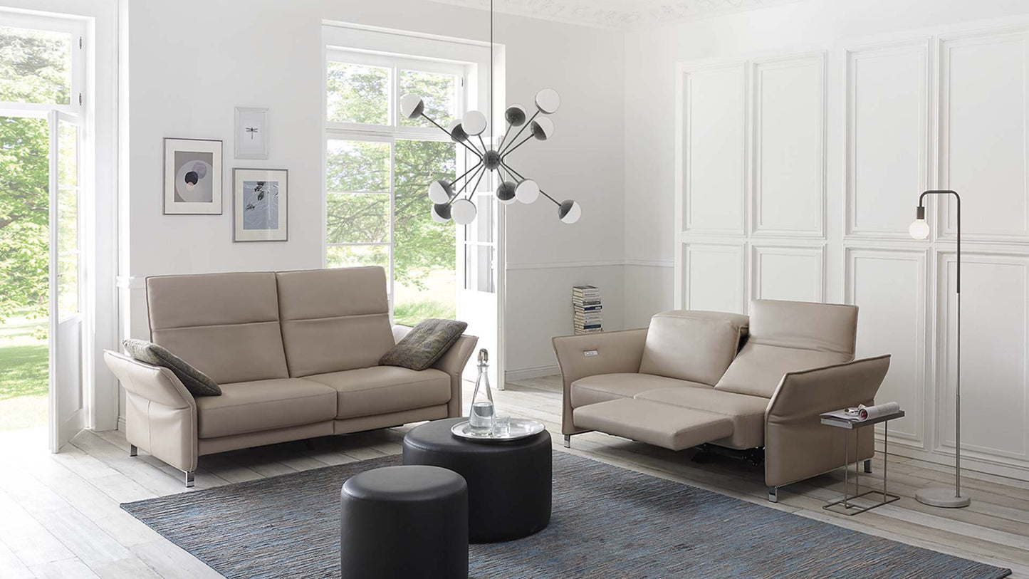 Elektrisch verstellbares Sofa in beigem Leder in einem hellen Wohnzimmer.
