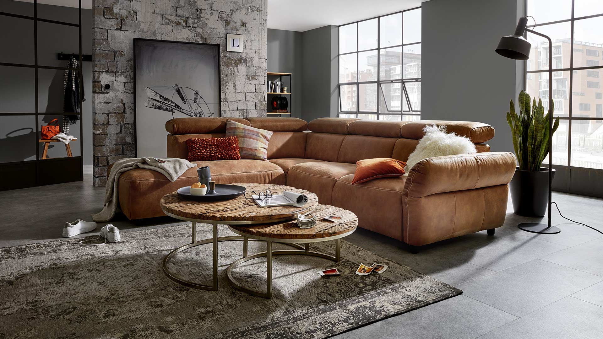 Elektrisch verstellbare Couch in braunem Leder in einemWohnzimmer im Industrial Style. 