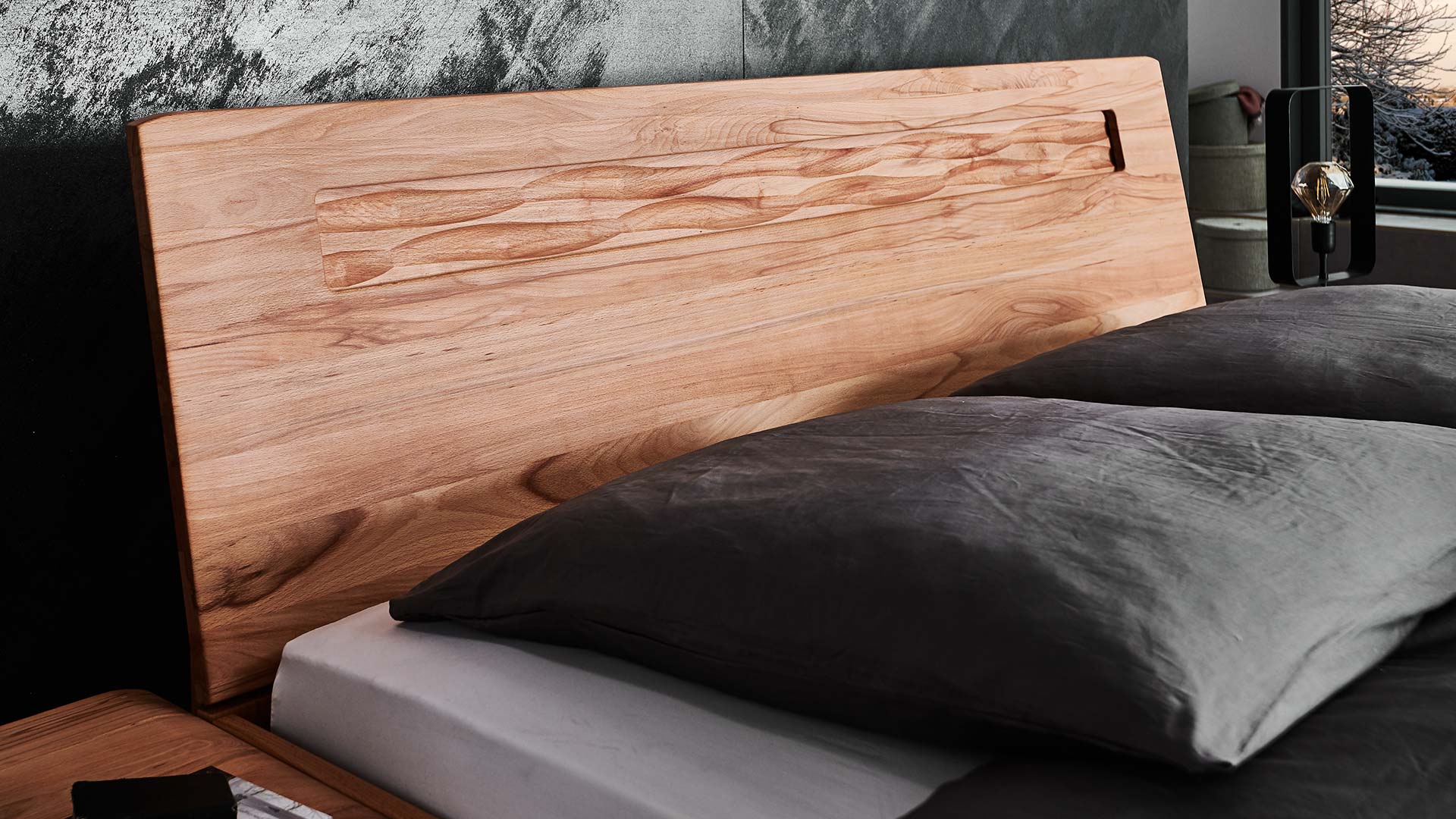 Schwarzes Schlafzimmer mit Holzbett aus Eiche oder Kernbuche mit geradem Rückenteil mit Ausschnitt aus Massivholz.