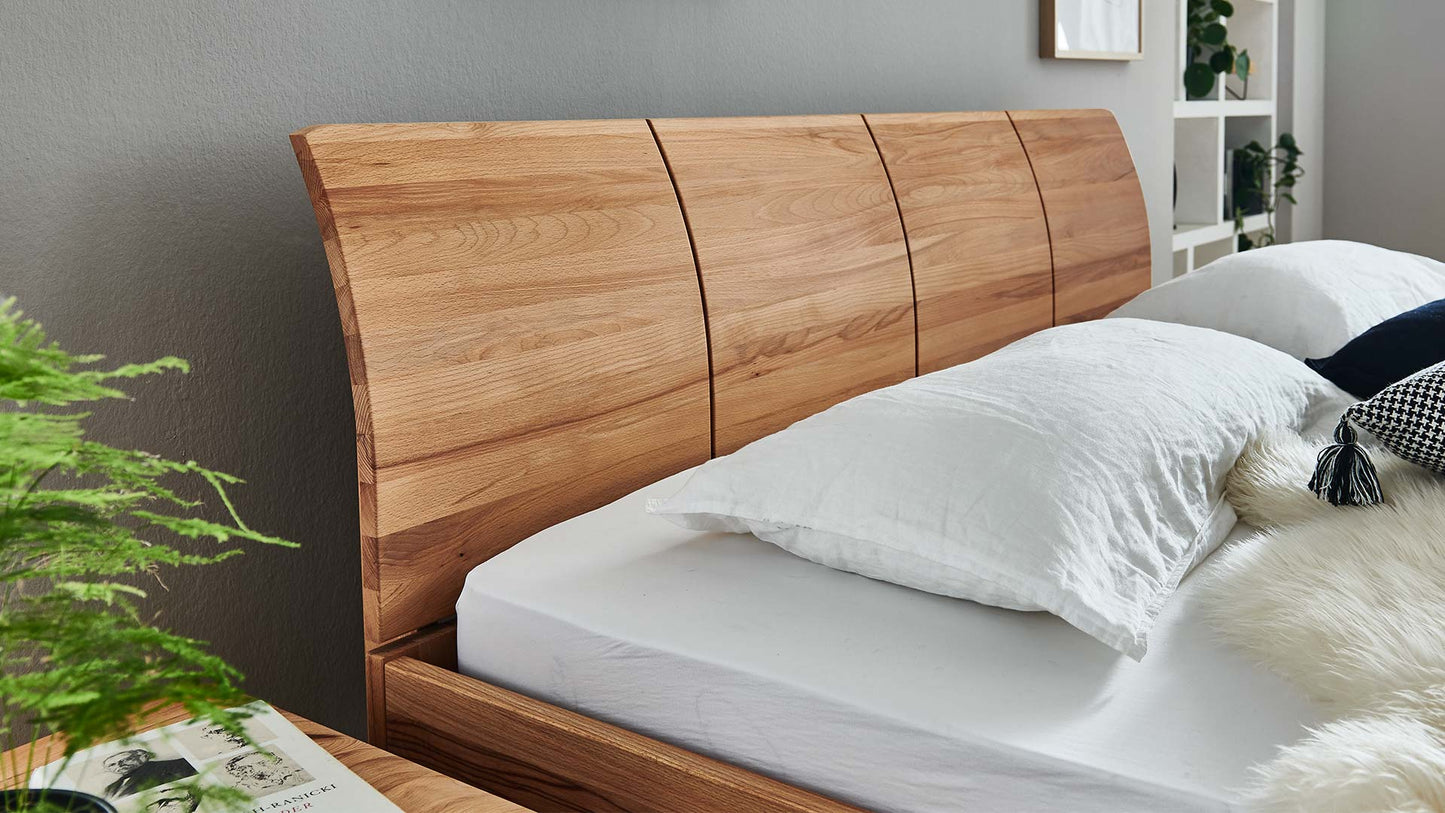 Gräuliches Schlafzimmer mit Holzbett aus Eiche mit gebogenem Rücken.