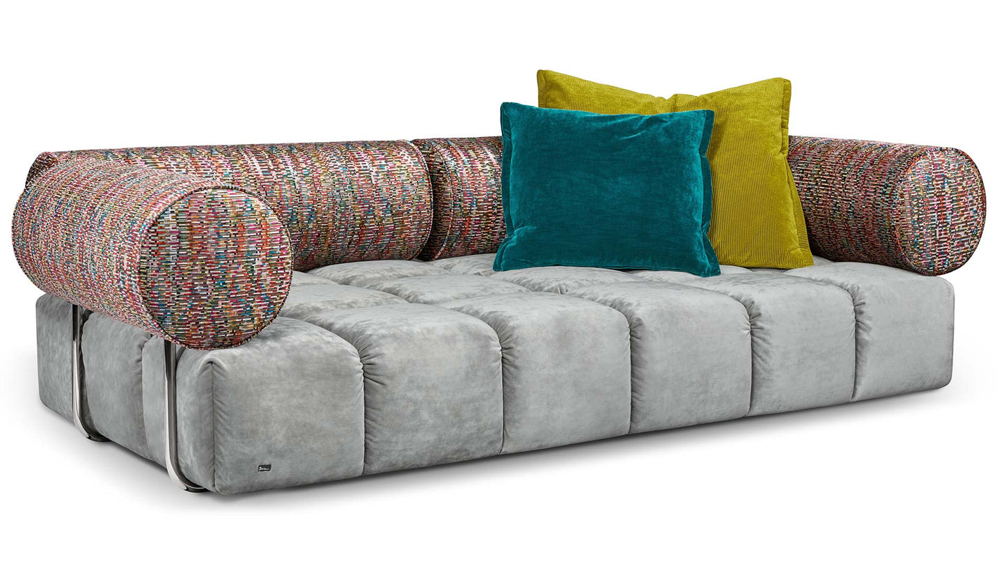 Ed Couch von Bretz silbernem Velours und bunt gemusterten Polsterrollen und blauem und gelbem Plaidkissen in Velours und Cord.