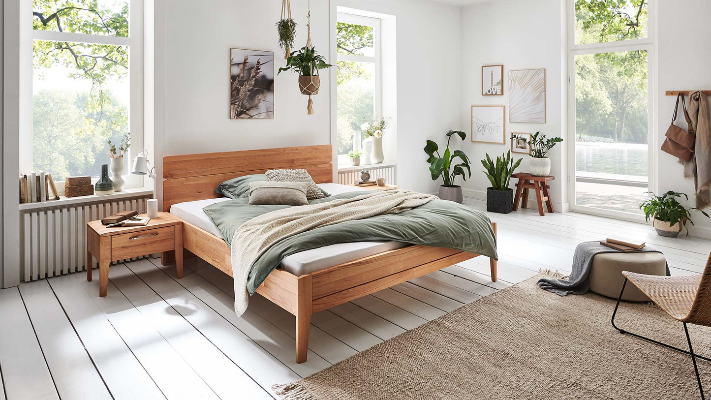 Weißes Schlafzimmer mit Holzbett aus Eiche oder Kernbuche mit geradem Rückenteil und Nachtkästchen aus Massivholz.