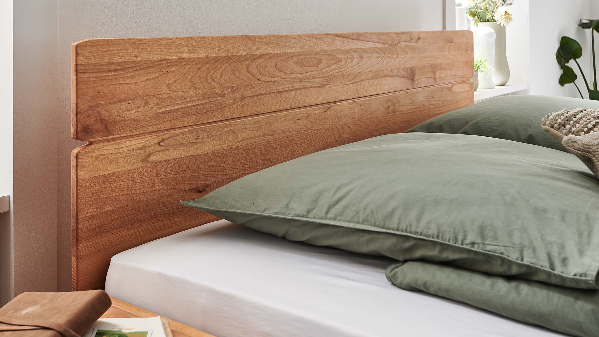 Weißes Schlafzimmer mit Holzbett aus Eiche oder Kernbuche mit geradem Rückenteil aus Massivholz.