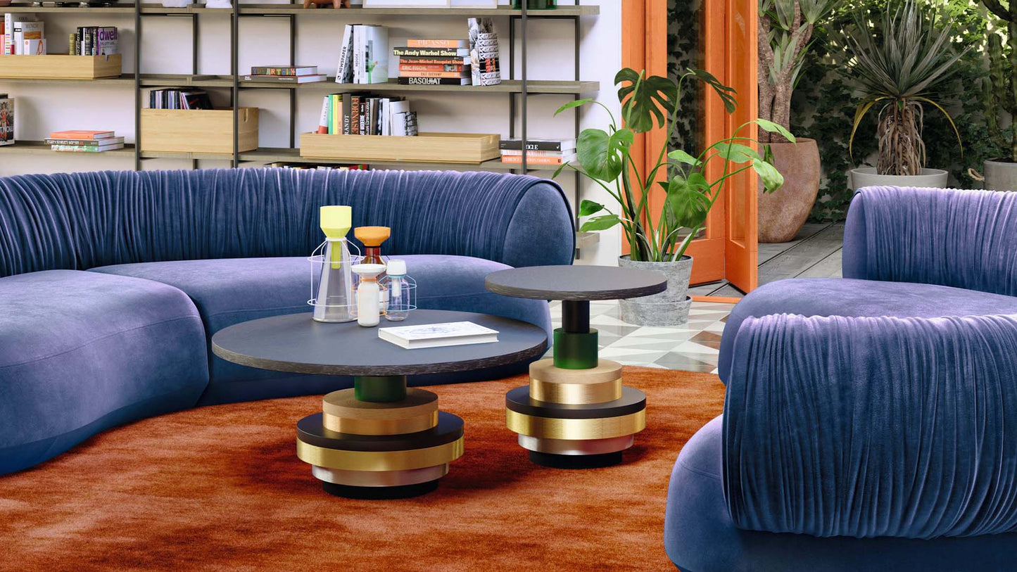 Wohnzimmer mit orangenem Teppich und dem Bretz Tisch Disquo in zwei Größen als Couchtisch.