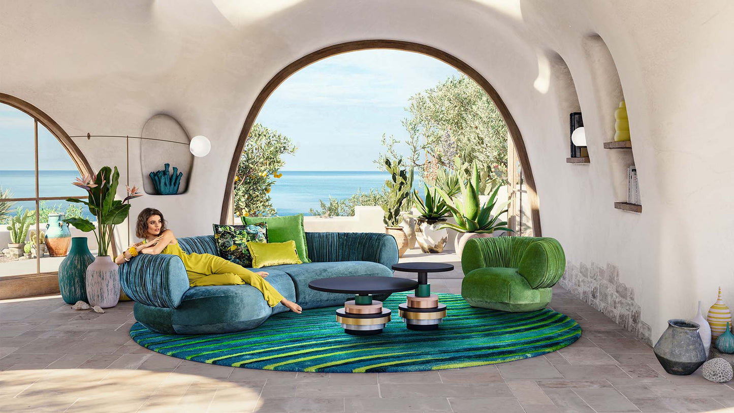 Gewölbtes Wohnzimmer am Meer mit Sofa und Bretz Sessel Nanami in grünem Samt.