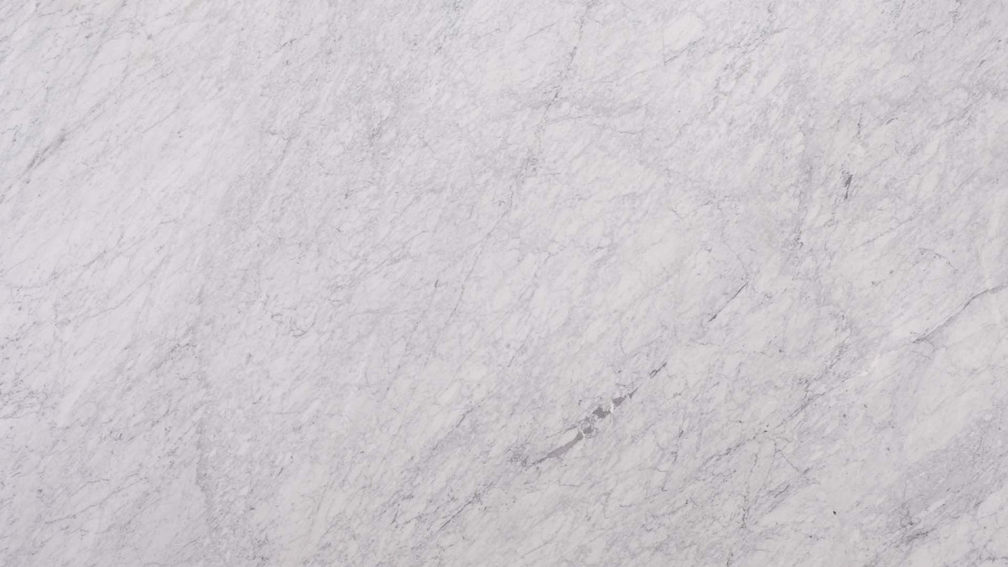 Marmor Arbeitsplatte in hellem, weißen Grundton und dunkel geaderter Struktur mit glitzernder, fein kristalliner Beschaffenheit in der Farbe Carrara.