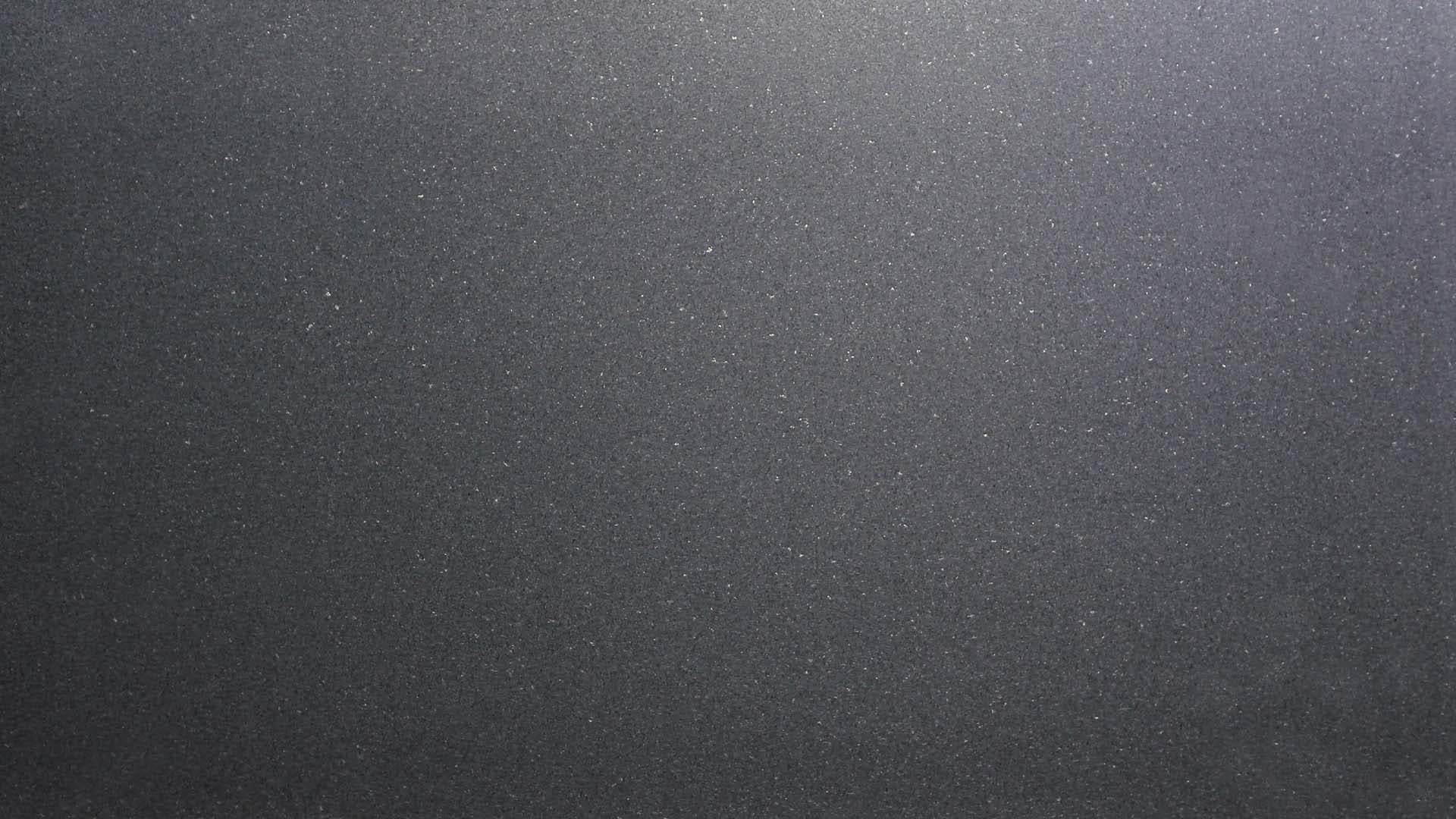 Naturstein Küchenarbeitsplatte in gesamt schwarz-atnhrazithfarbender, ruhiger und feiner Oberfläche mit dezent weißen Einsätzen in semi gloss in der Farbe Argento Black.