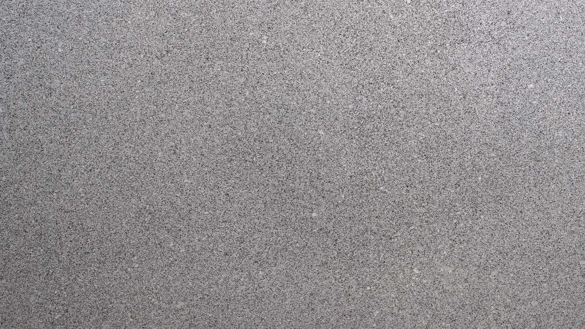 Naturstein Küchenarbeitsplatte mit weißer Grundfarbe im matten leather look mit grundsätzlich feiner Struktur und schwarz-grauen Sprenklern in der Farbe Gamma White.