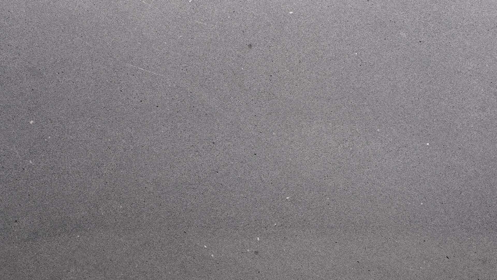 Naturstein Küchenarbeitsplatte in grauem Gruntnon und minimalistischer Maserung in weiss-grau-schwarz und allgemein sehr feiner, matter Oberflächenoptik in der Farbe Mühltalsee.