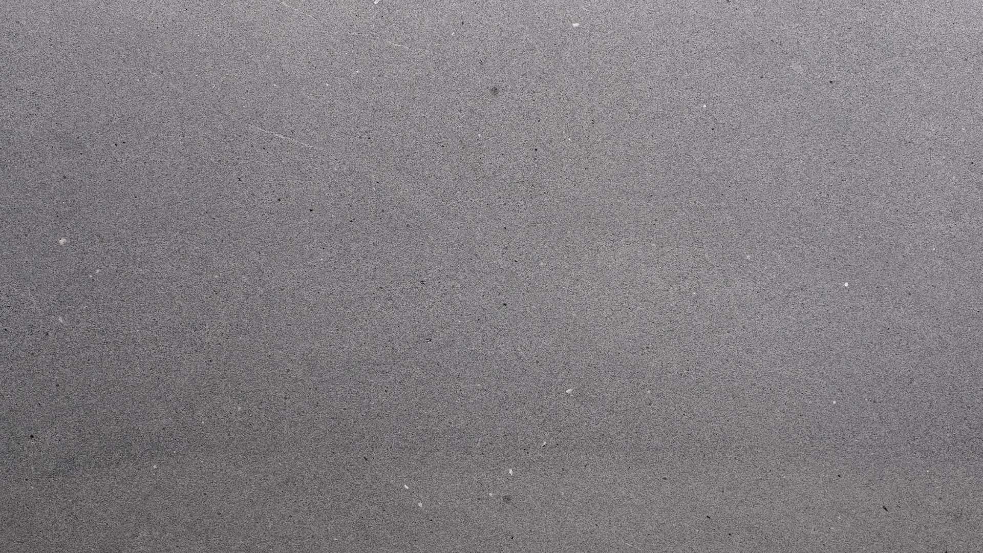 Naturstein Küchenarbeitsplatte in grauem Gruntnon und minimalistischer Maserung in weiss-grau-schwarz und allgemein sehr feiner, matter Oberflächenoptik in der Farbe Mühltalsee.