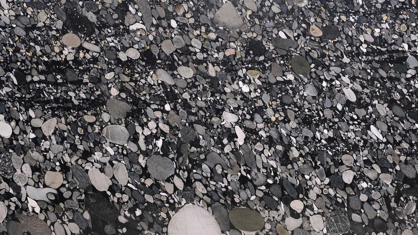 Naturstein Küchenarbeitsplatte poliert in der Grundfarbe schwarz mit klar erkennbaren, einzelnen Steinen in den Farben grau und grün in der Farbe Nero Marinace.