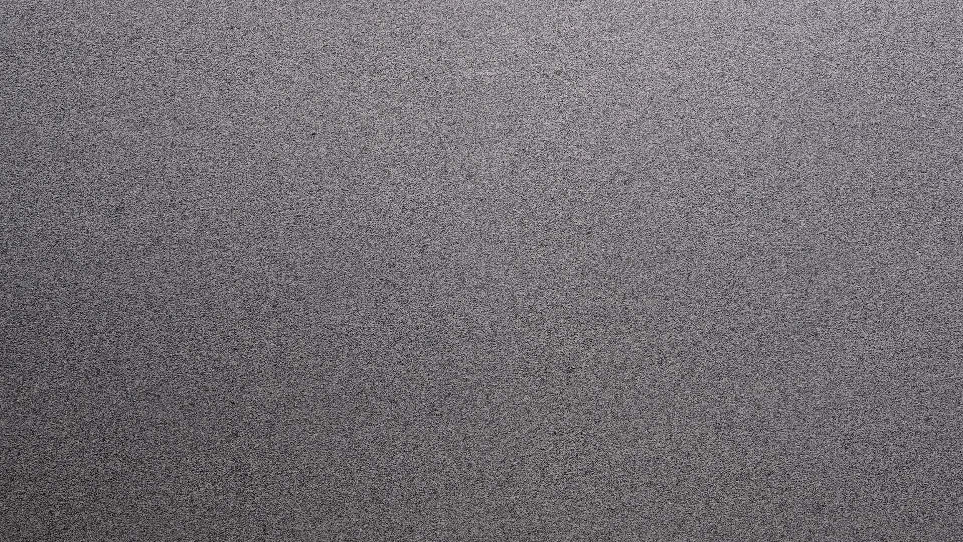 Naturstein Küchenarbeitsplatte mit weiß-hellgrauer Grundfarbe im matten leather look mit allgemein feiner Struktur und feinen, schwarz-grauen Sprenklern in der Farbe Plöckinger.