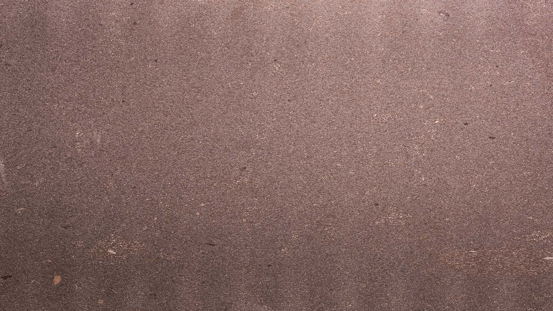 Naturstein Küchenarbeitsplatte in weichem Bordeauxrot mit weiß-rosaner, feiner Musterung im matten leather look in der Farbe Porphyr Valcamonica.